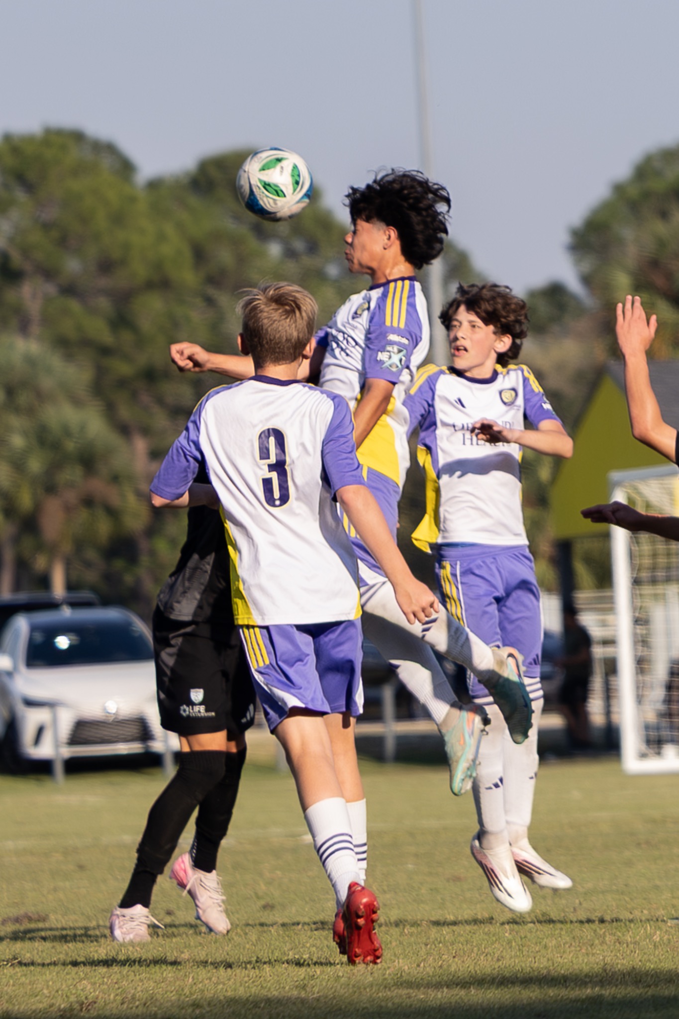 Youth soccer player heading ball in match — sports action photography Port Orange FL — Heidi Lynne Photography